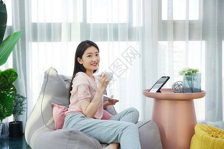女性休闲居家生活阳台上喝咖啡背景图片
