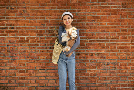 清新美女抱着宠物狗出游逛街图片