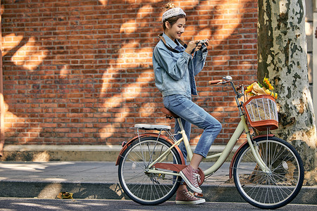清新美女骑自行车出游坐在车上看照片高清图片