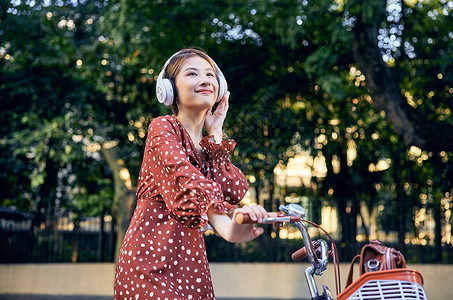 俯瞰树林与街道清新美女骑车听音乐背景