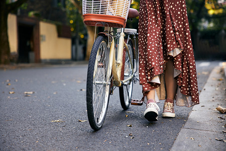 推着自行车走清新美女在马路上推着自行车特写背景