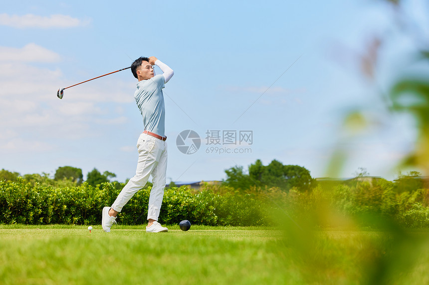 挥杆打高尔夫球的男性形象图片