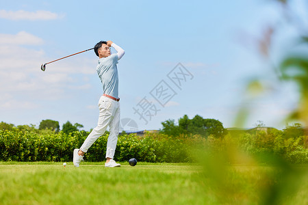 挥杆打高尔夫球的男性形象图片
