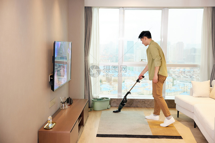 年轻男性居家清洁木地板图片