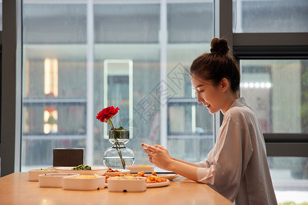 青年美女使用手机记录美食高清图片