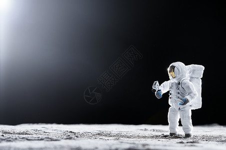 创意太空素材站在月球表面手拿探测器的宇航员背景