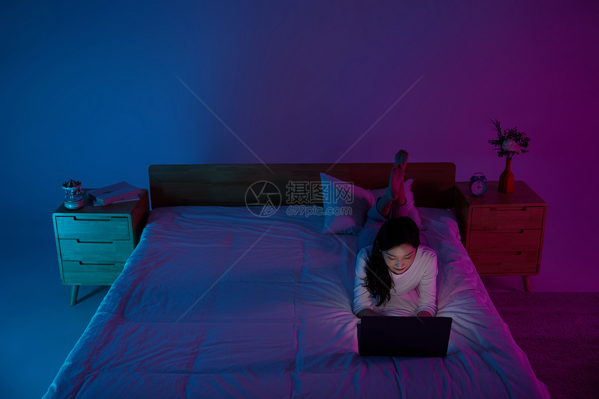 女性失眠熬夜通宵躺床上使用电脑图片