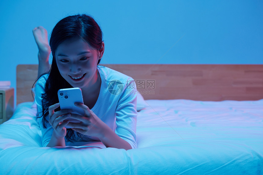 女性失眠熬夜通宵躺床上玩手机图片