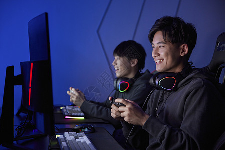 青年男孩组队使用手柄玩电脑游戏图片