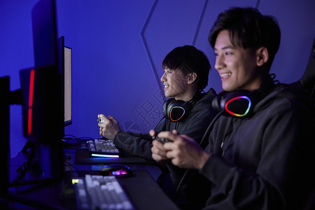 青年男孩组队使用手柄玩电脑游戏图片