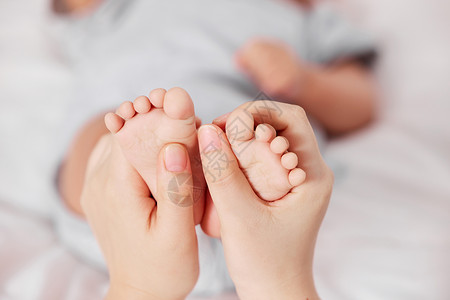 妈妈手托新生婴儿的小脚高清图片