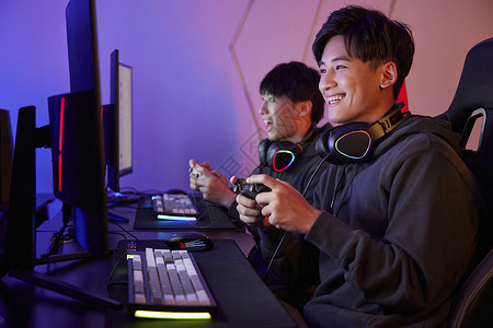 青年男性熬夜通宵使用手柄玩电脑游戏高清图片