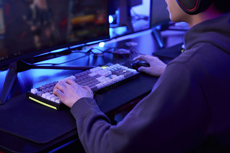 男孩与计算机年轻人坐电脑前打网络游戏背景