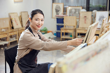 在通书本素材在画室画画的女性形象背景