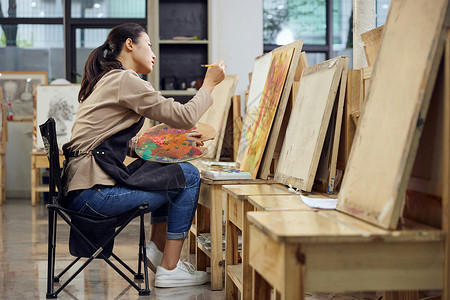 在画油画的女孩在画室画色彩画的女性背景