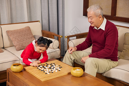 春节期间小女孩和爷爷下围棋图片