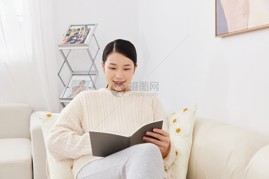 孕期妈妈居家坐沙发上看书图片