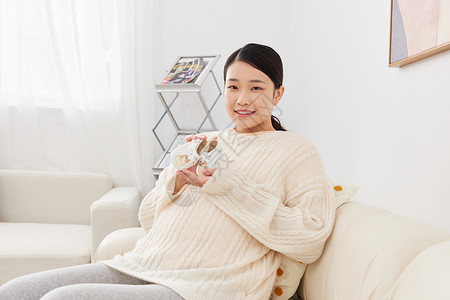 孕期准妈妈手捧婴儿鞋子图片