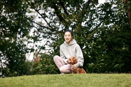 端午节玩耍少女在公园里和泰迪一起玩耍的运动少女背景