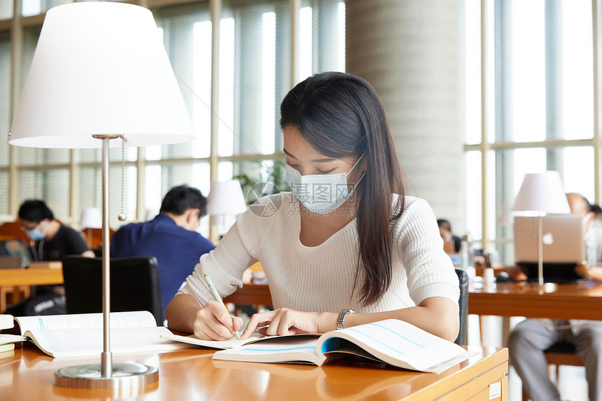 戴口罩的女学生在自习室学习图片