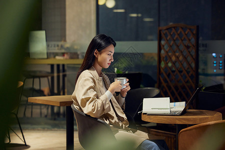 室外作业青年女性在咖啡馆使用电脑学习备考背景