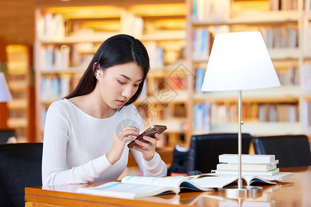 高考素材手机女学生图书馆学习使用手机查资料背景