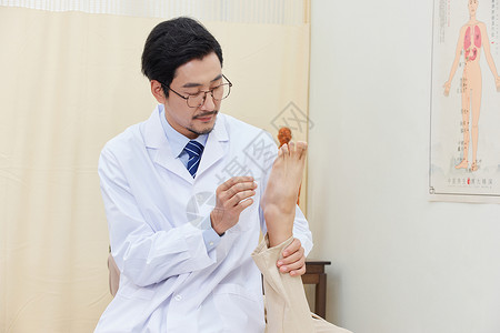 男中医为患者脚背做针灸高清图片