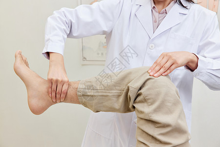 按摩男性医生检查患者膝关节特写背景