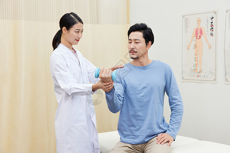 中医病房女护士引导男患者举哑铃做手臂复健背景