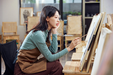 在画油画的女孩女性独自在画室里画画背景