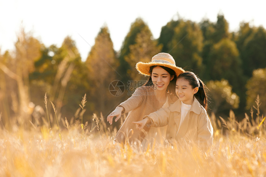 母女二人秋天在稻田里郊游图片