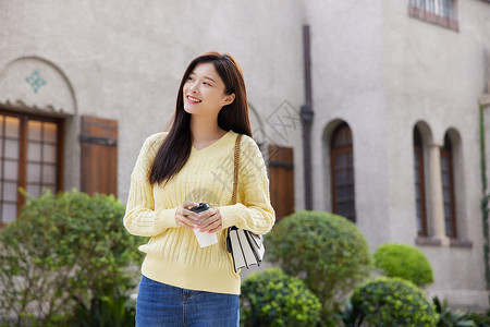 对象存储手拿咖啡等候约会对象的青年女性背景