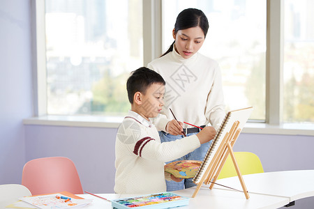 美术班招新美术老师教小男孩色彩画背景