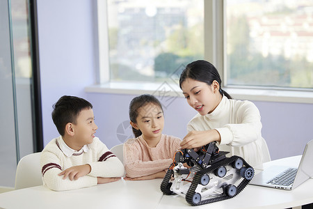 操作指导老师指导小朋友操作编程机器人背景