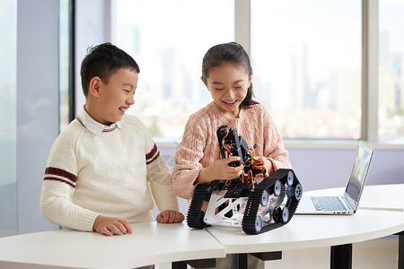 男生女生兴趣班上体验编程机器人操作素质教育高清图片素材