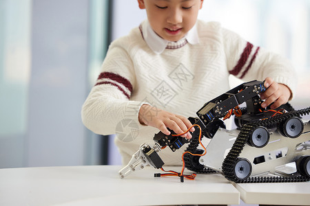 小孩玩机器人少儿编程课上实操的小男孩特写背景
