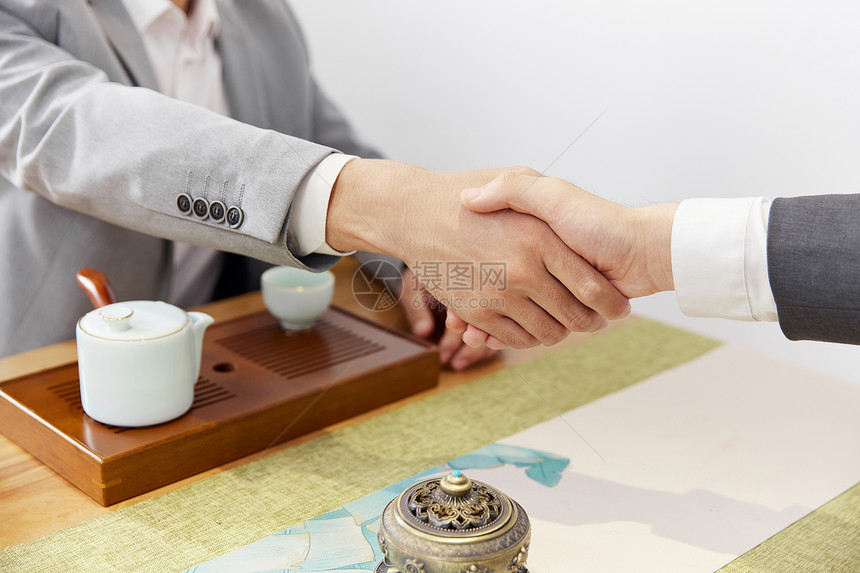 商务人士在茶室谈生意合作握手特写图片
