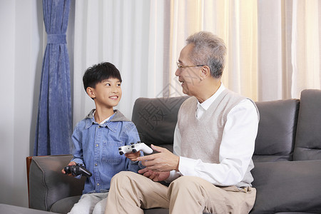 爷爷和孙子一起玩游戏家庭生活高清图片素材