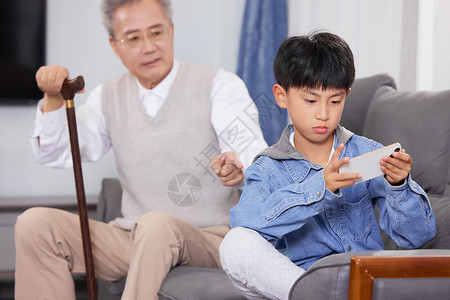 坐着吃瓜的爷孙爷爷教育玩手机的孙子背景