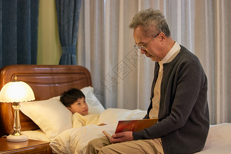 爷爷给孙子讲睡前故事哄睡觉东方人高清图片素材