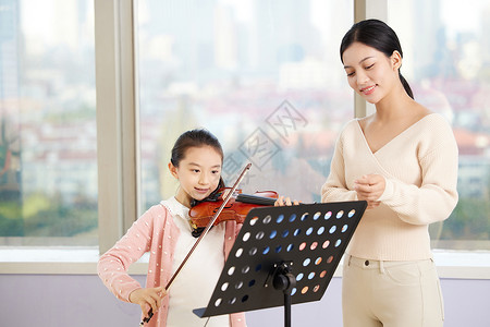 乐器学习女老师指导小女孩拉小提琴背景