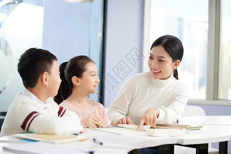 年轻女老师辅导小朋友学习图片