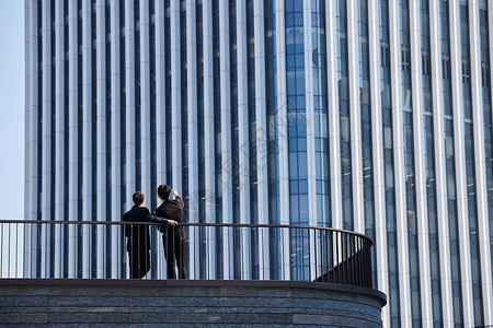 站在阳台站在高楼前的商务人士背影背景