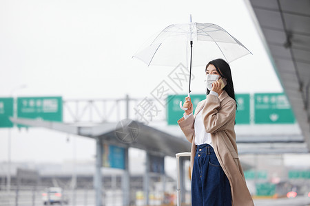 戴口罩在机场打车的女性背景图片