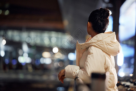 美女夜间出行站路边背影图片