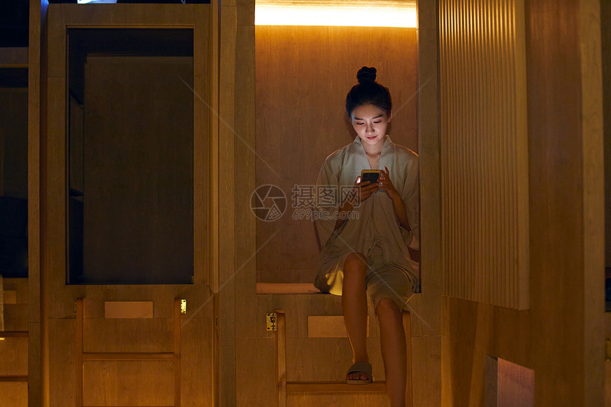美女在汤泉馆休息区玩手机图片