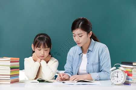 女性教师辅导小学生学习图片