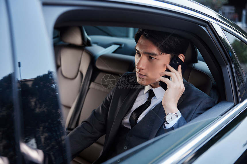 年轻商务白领坐在轿车里打电话图片