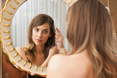 女人对着镜子梳头图片