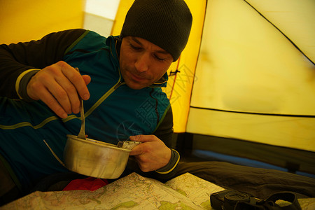 男人在露营帐篷里吃饭图片